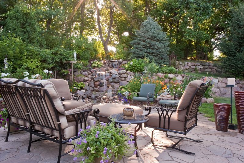 stone floor patio with lounge chairs and beautiful landscaping